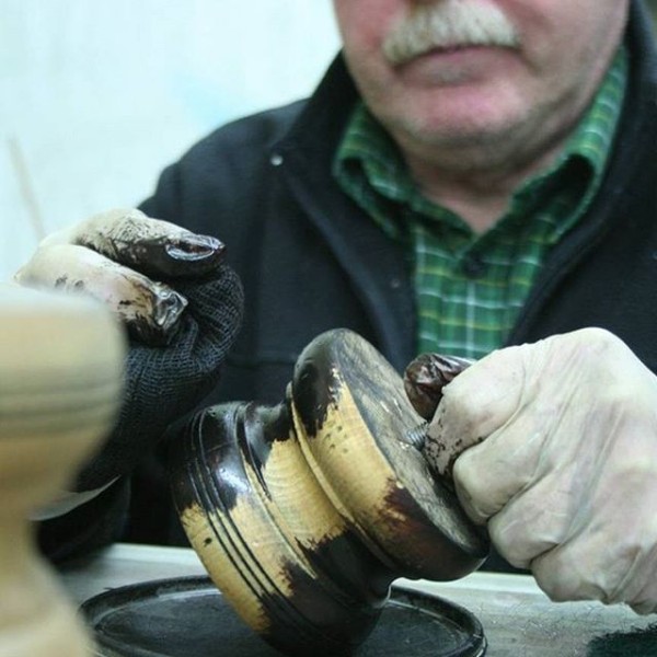 Hand crafted furniture - Applying the finish to the feet on a piece of Tetrad furniture 